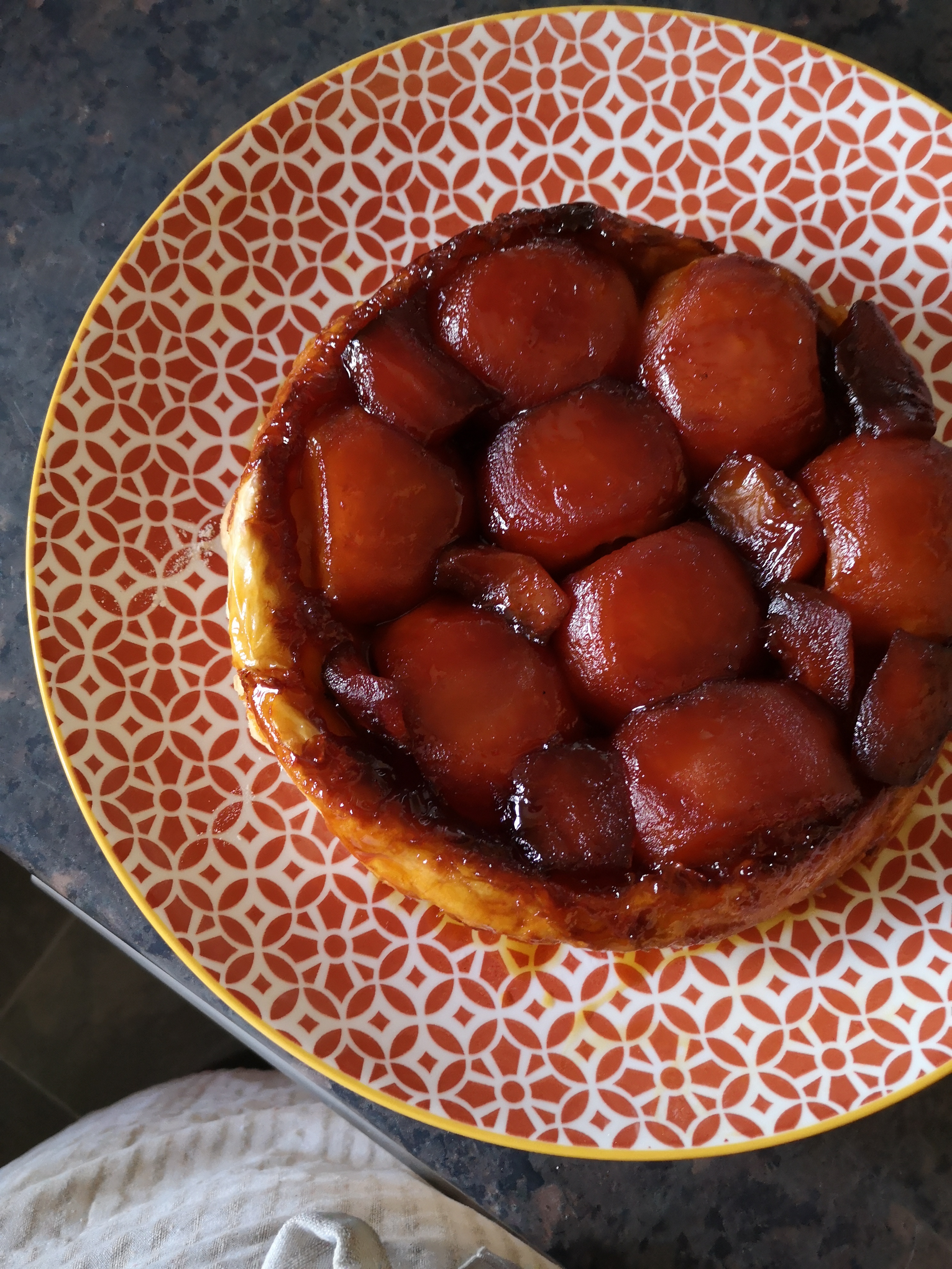 A tarte tatin de pommes on a patterned plate