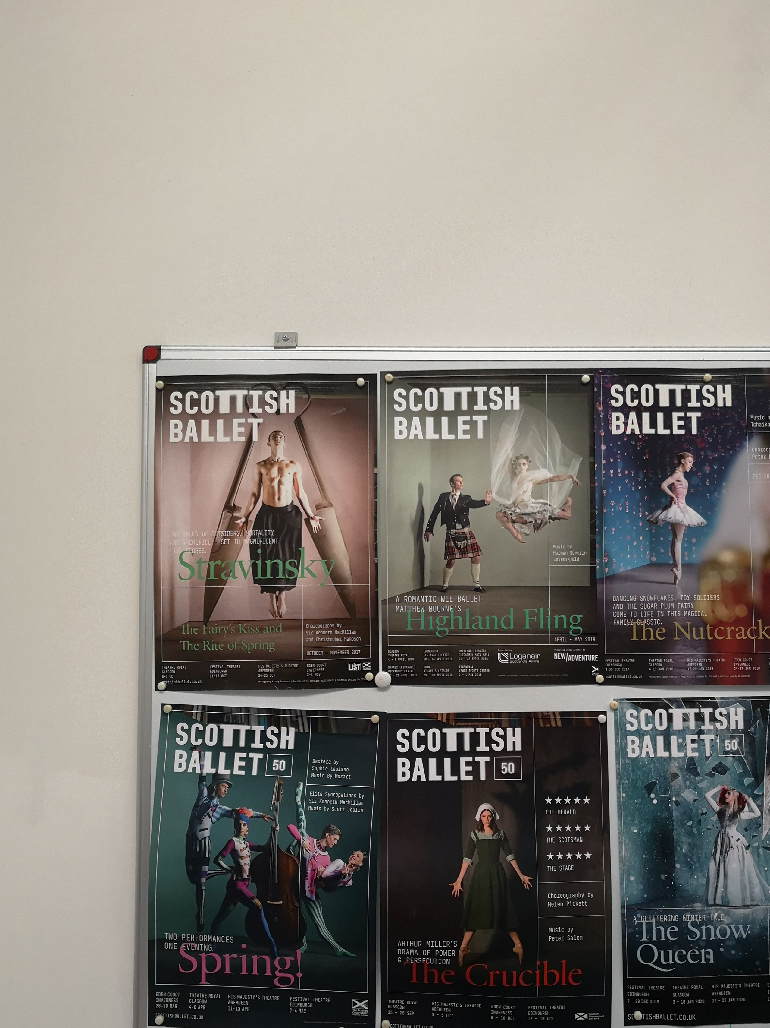 A board with many Scottish Ballet posters stuck to it