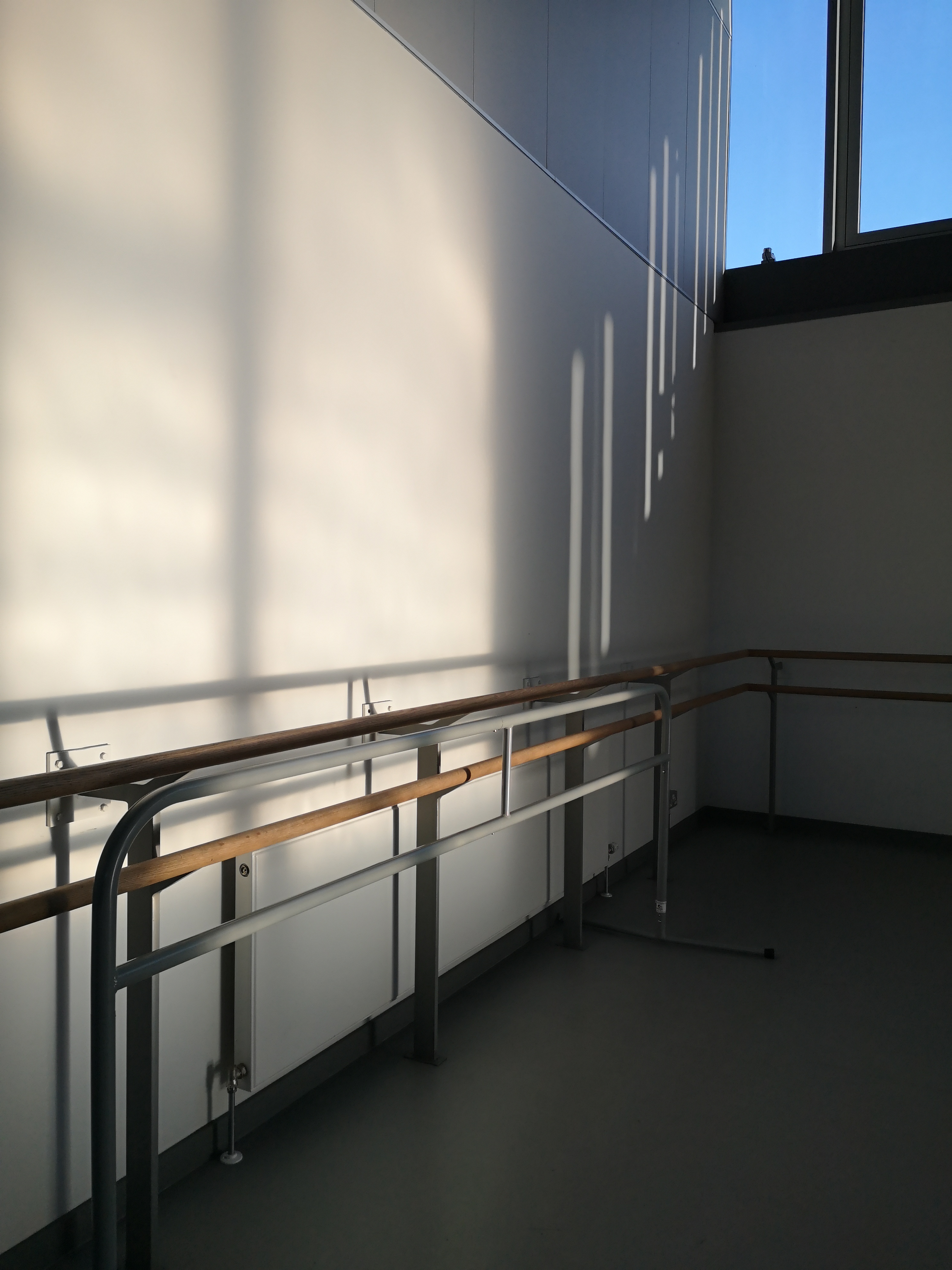 Sunlight hits a dance studio illuminating the ballet barres
