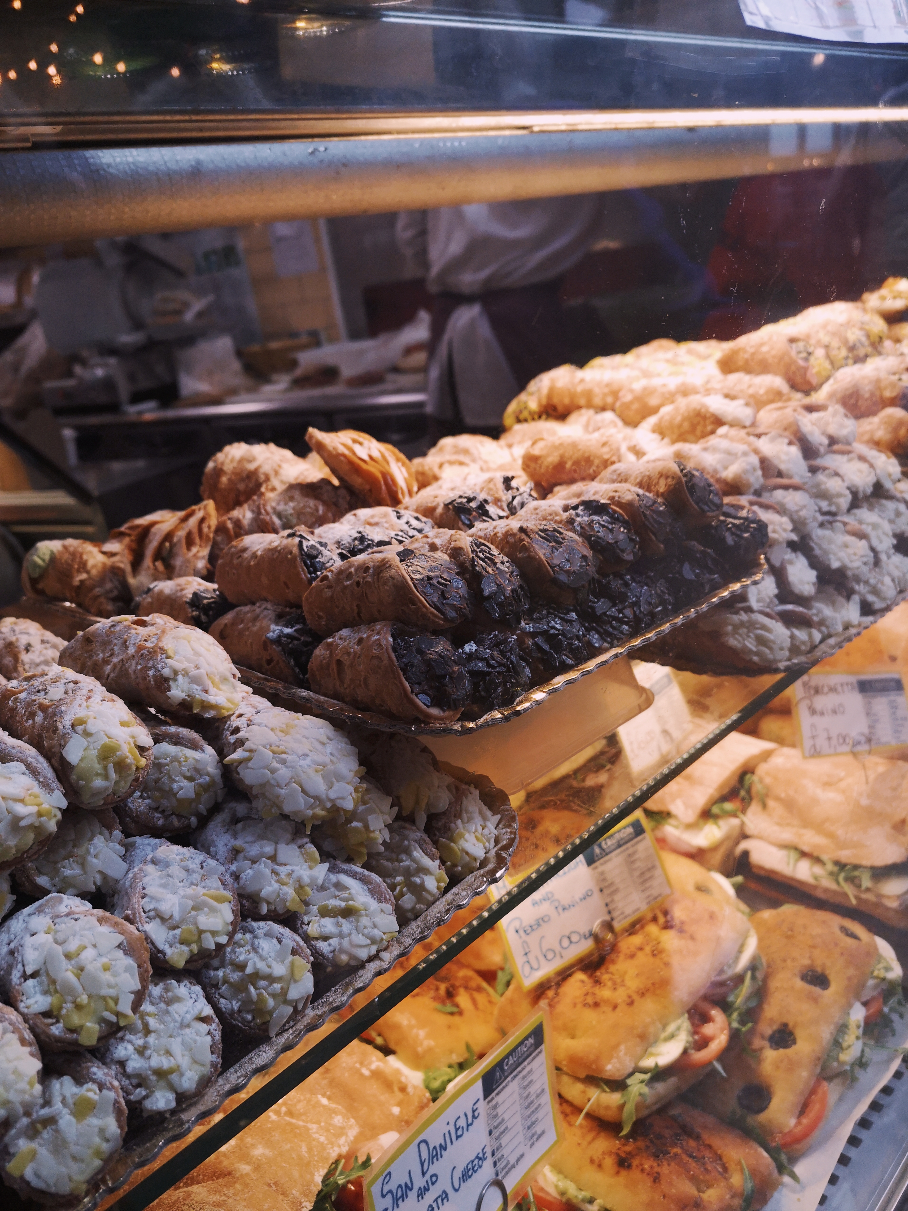 A stack of cannolis in a glass case