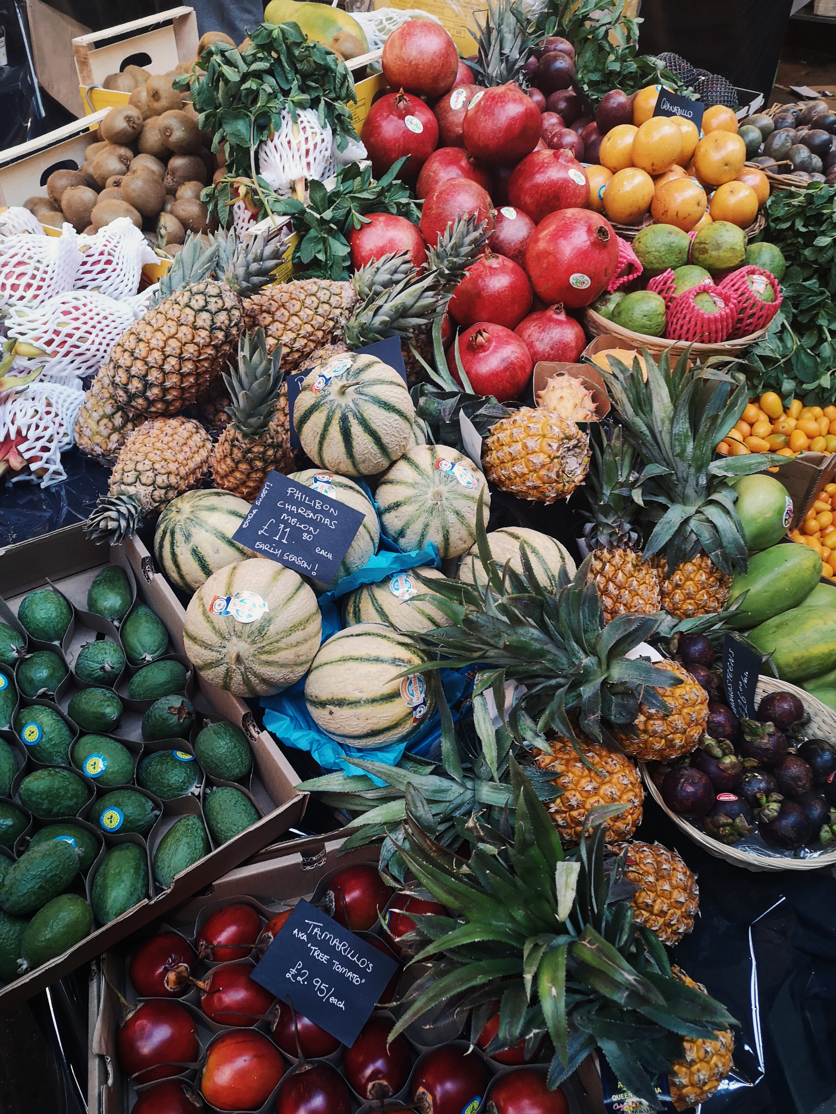 Various different colourful fruits piled up in baskets and boxes