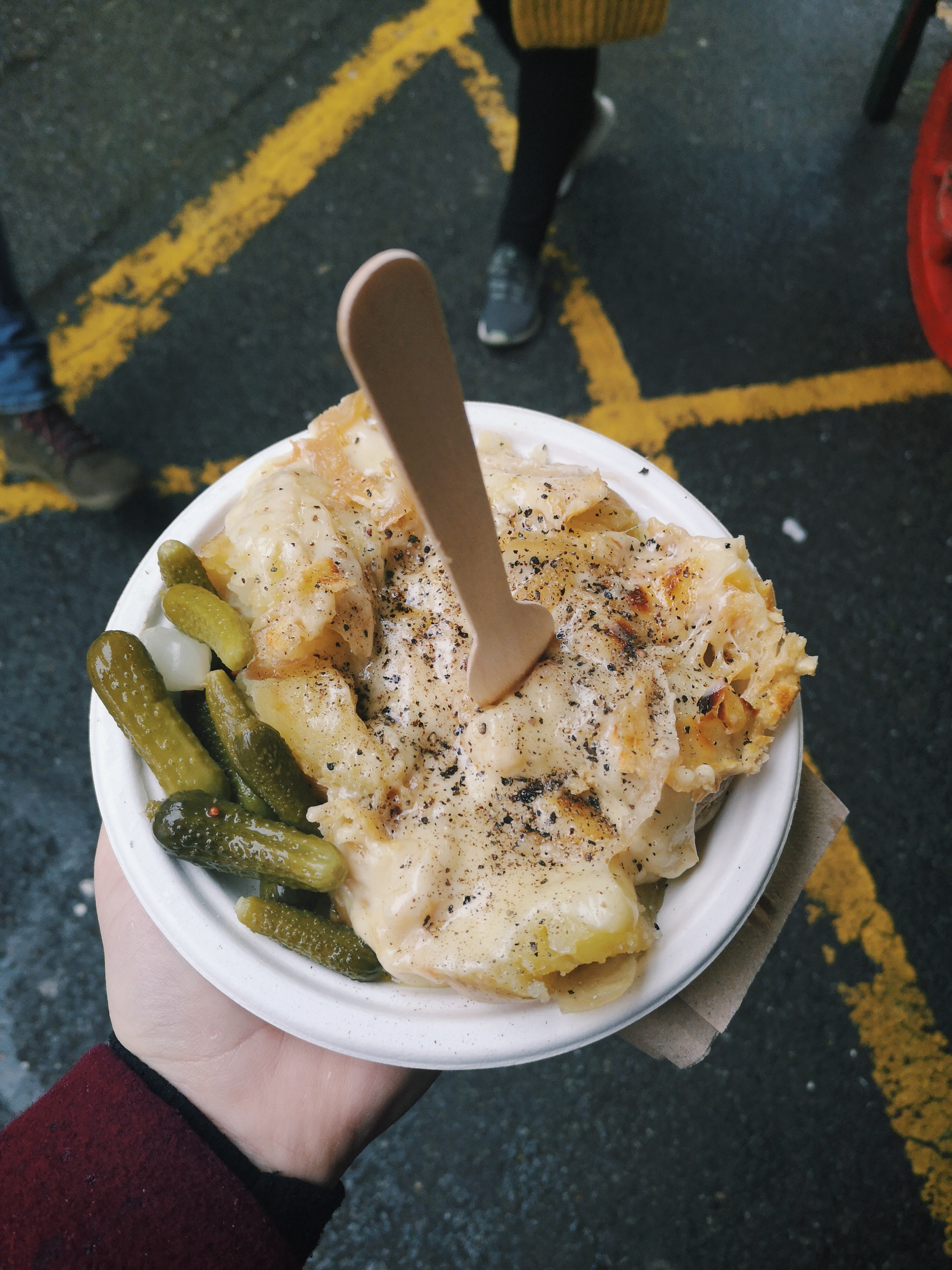 Raclette - melted cheese on top of potatoes and pickles on the side