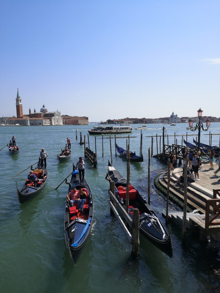Many gondolas parked near the dock in Venice