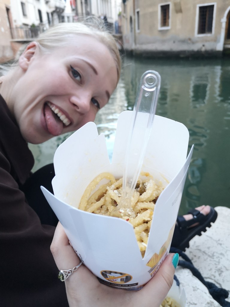 I hold a takeaway box full of pasta while Matilda sticks her tongue out to the camera