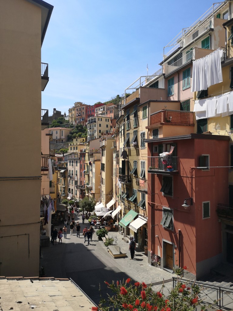 A beautiful street in an italian village, colourful buldings stack beside and above one another