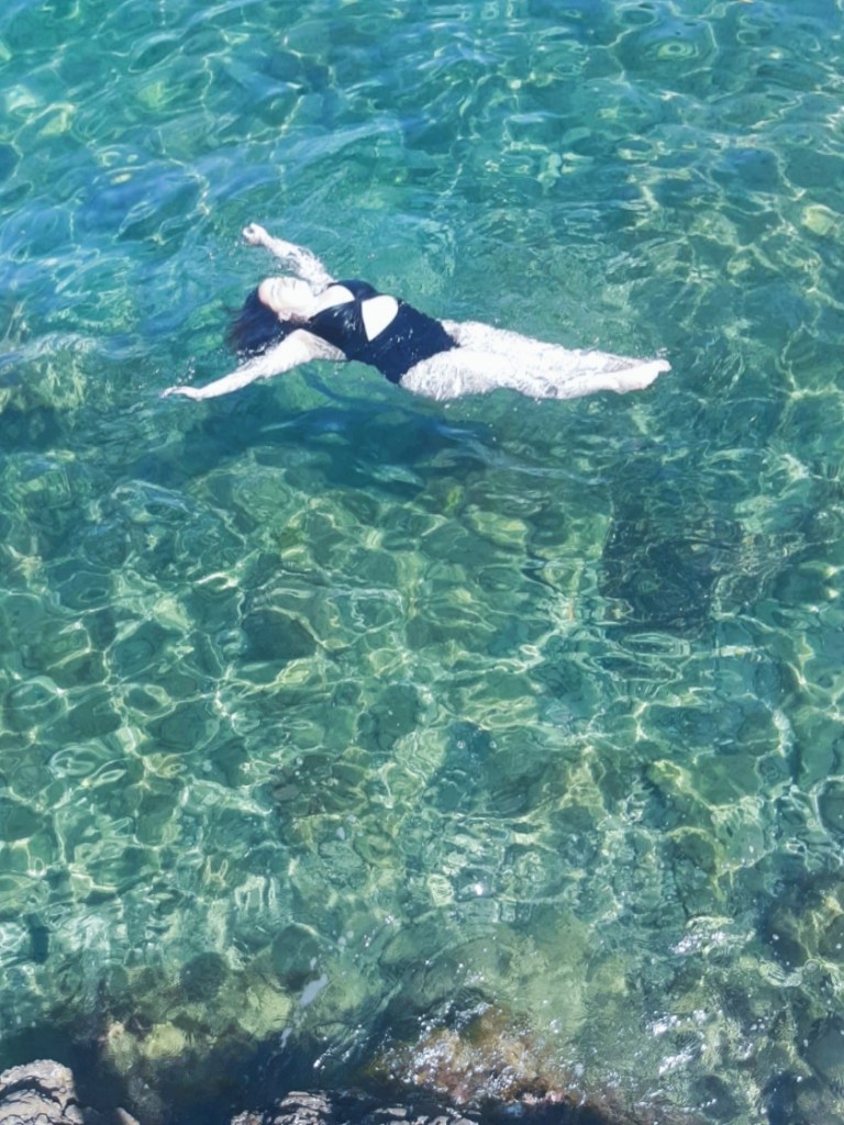 A super duper white Katie floats in the clear aquamarine water