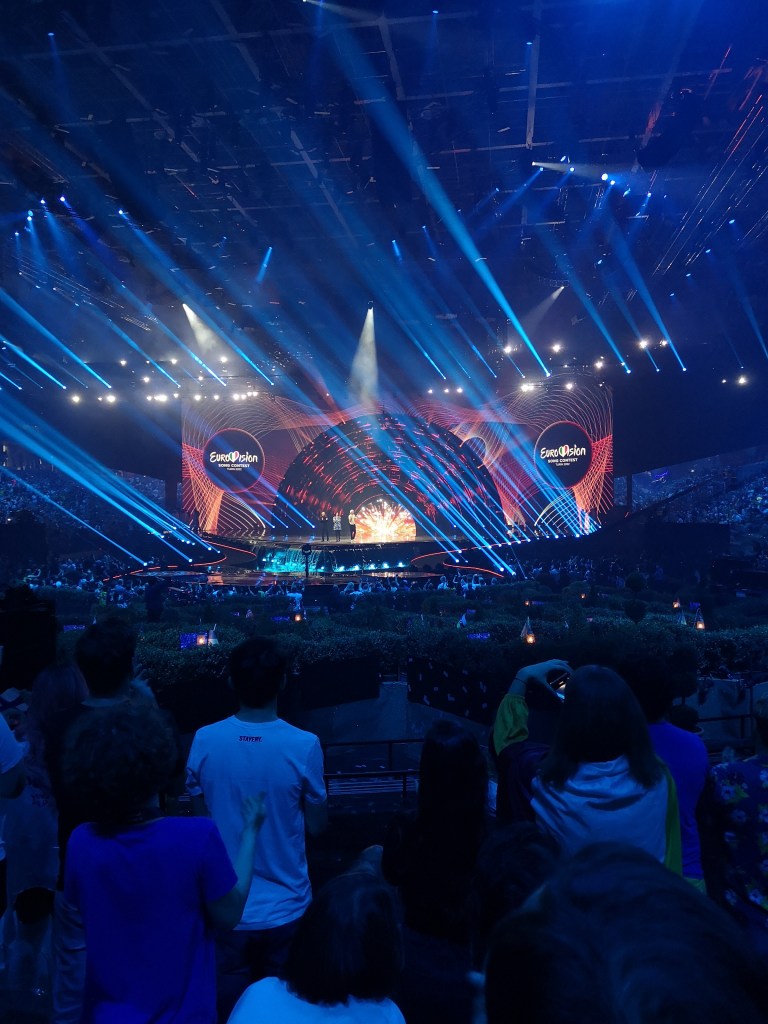 The Eurovision stage with the logo on the screen and blue rays of light shining out