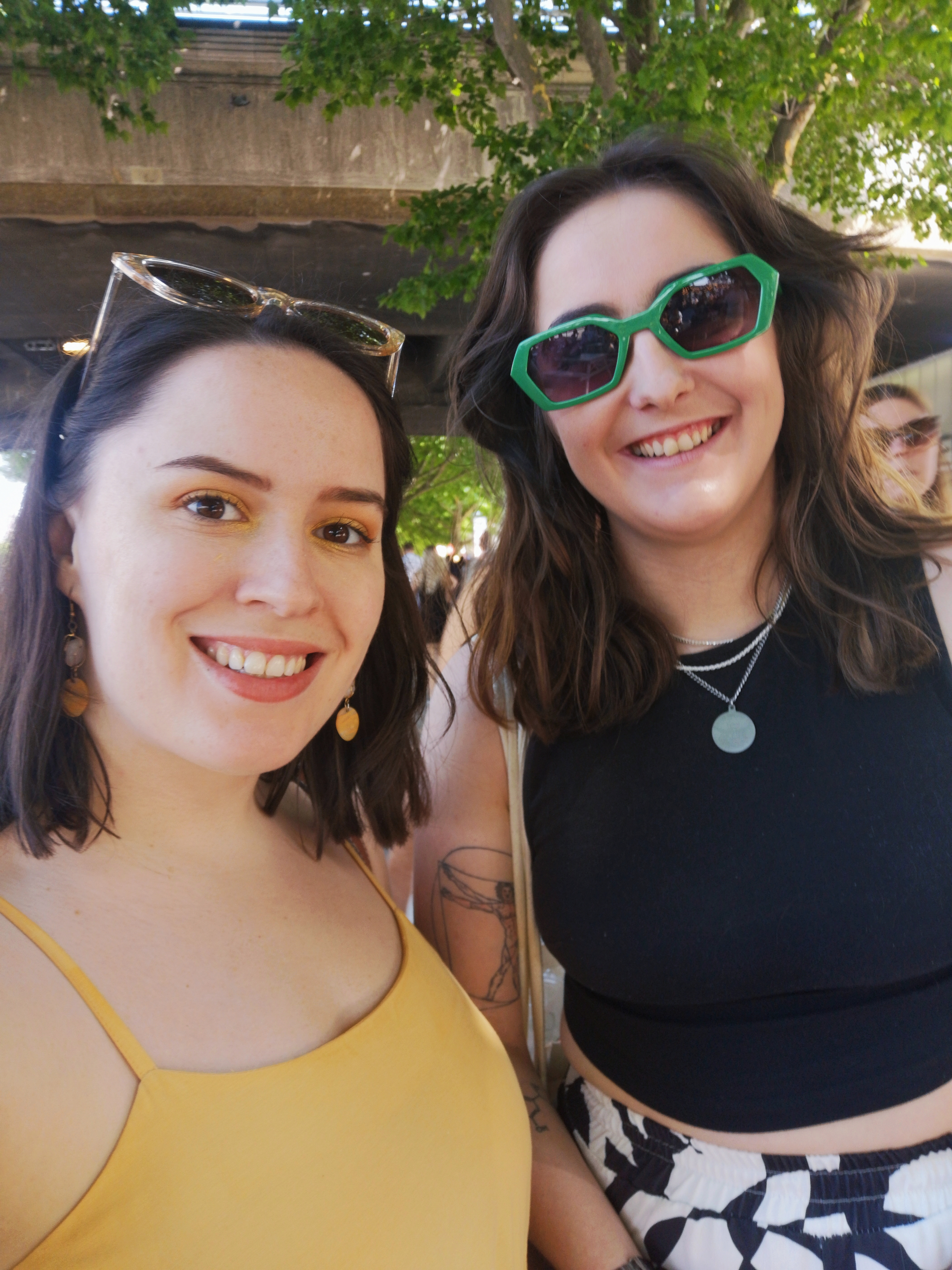 Two gals/sisters smile to take a photo together