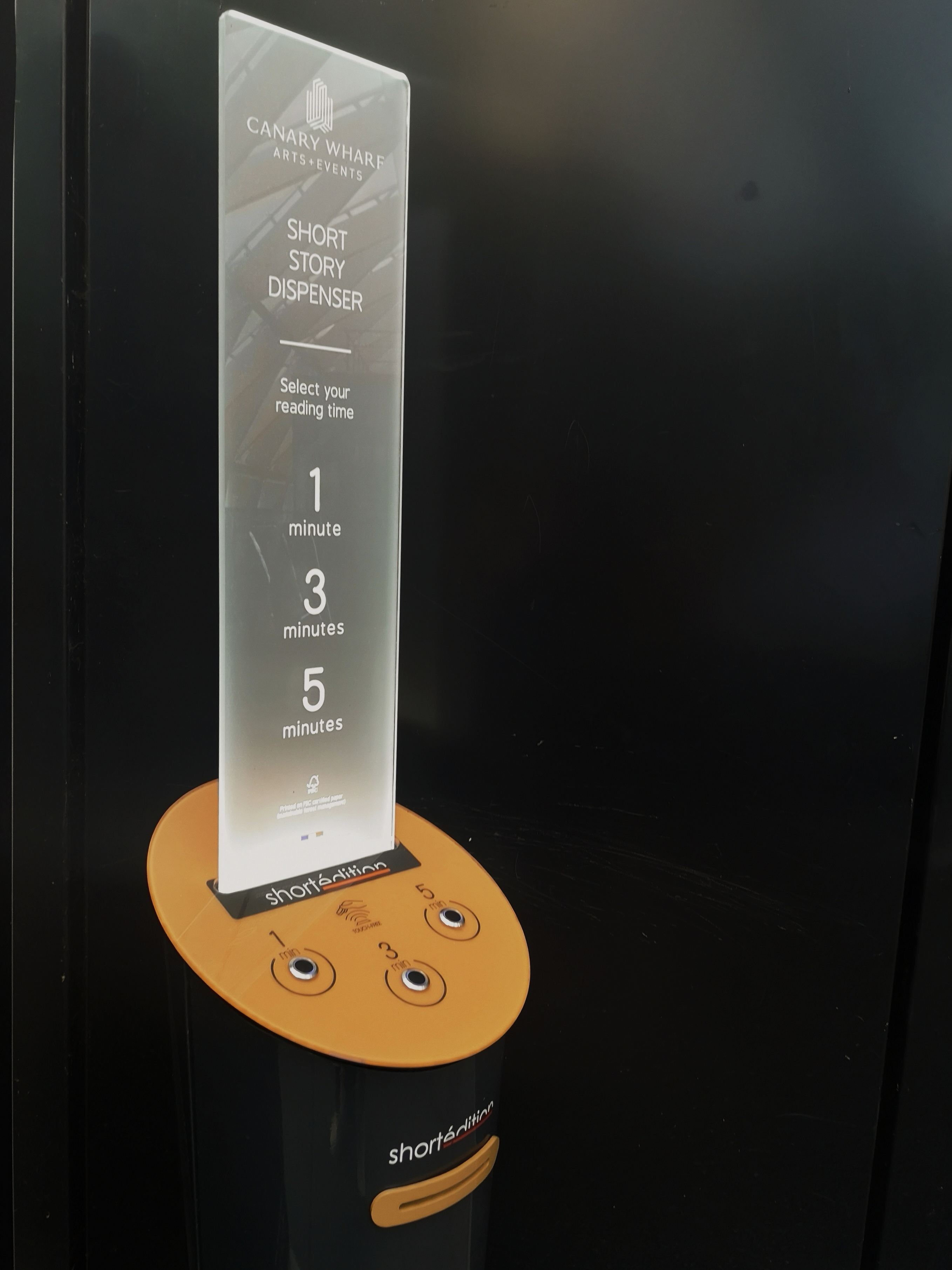 The Short Story dispenser machine has a sign with instructions and a panel with three buttons on it