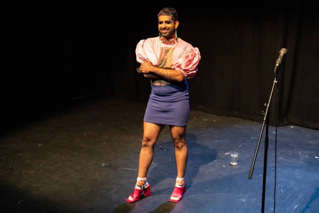 Alok stands with their arms crossed and smiles