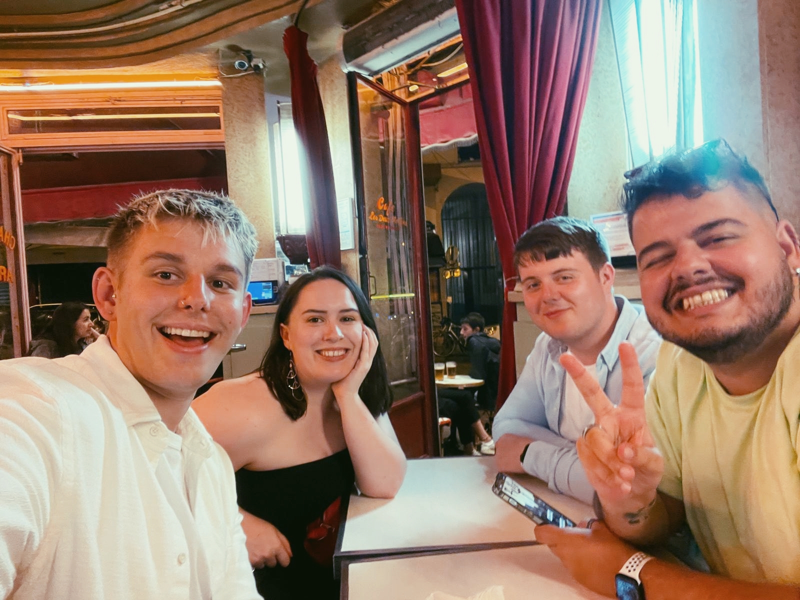 Four lovely humans smile at the camera while taking a selfie