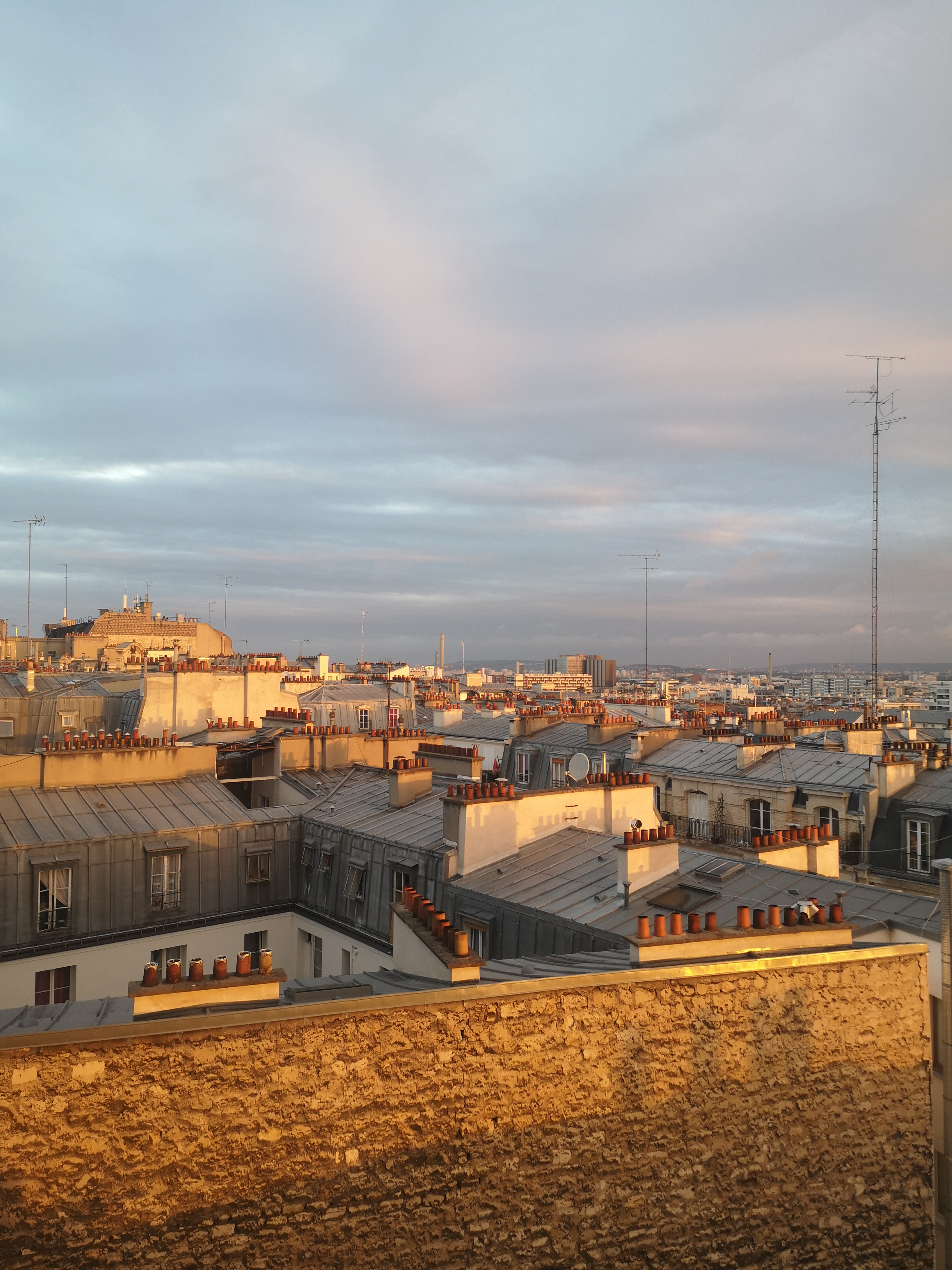 The view from my airbnb, rooftops and chimneys as far as the eye can see, glowing in the sunrise
