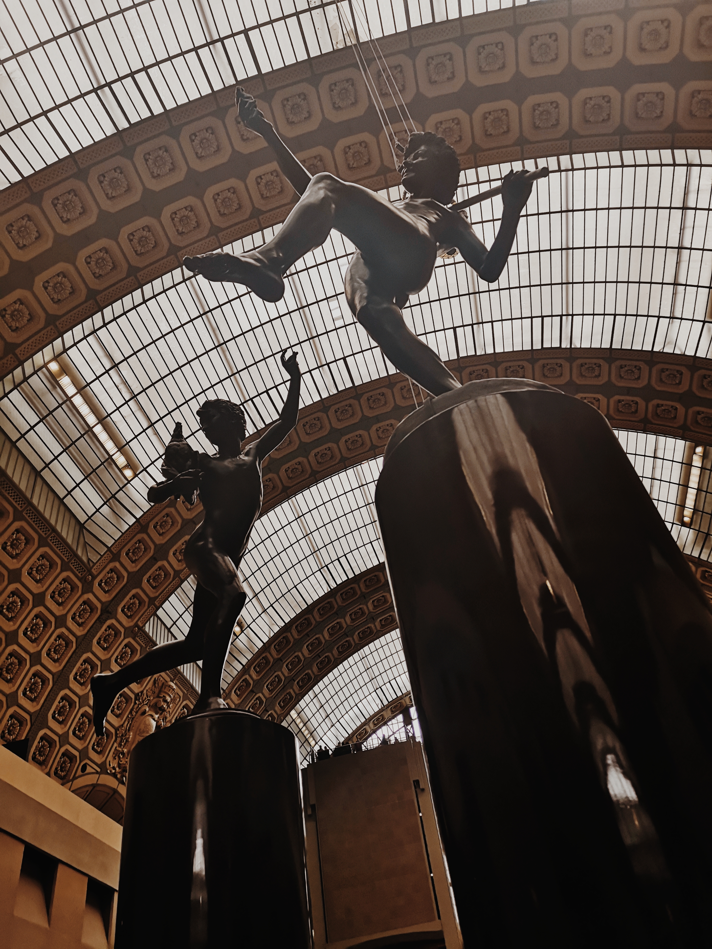 Two little angel sculptures strike poses on top of black cylinders