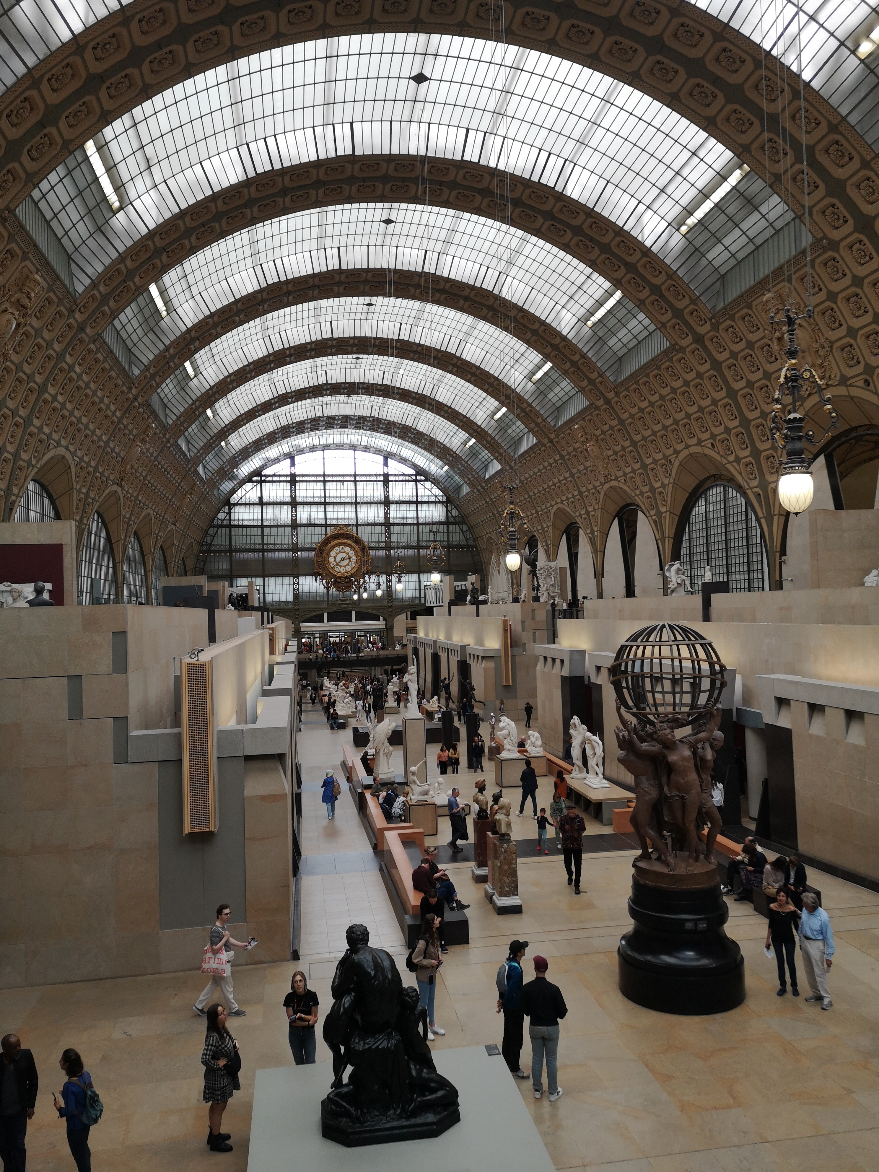 Loads of sculptures hanging out in a gorgeous big room with a curved ceiling