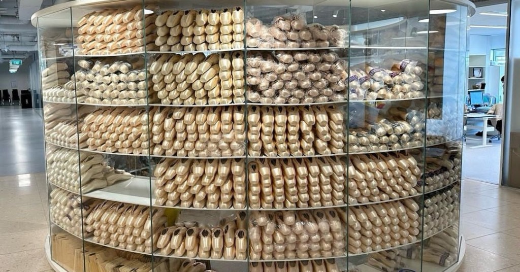 A round cabinet filled with stacks of pointe shoes