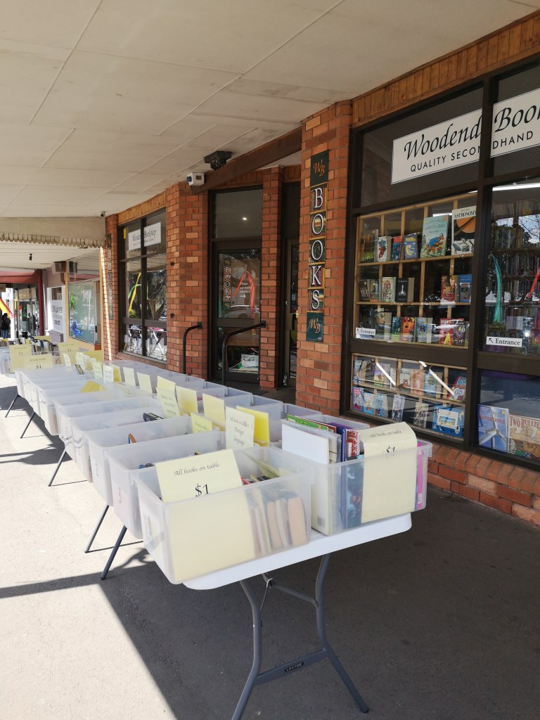 Outside a bookshop is tables with boxes of second hand booked begging you to browse through them
