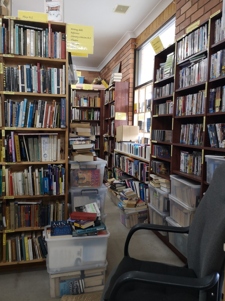 Shelves and boxes full of books piled up in a room