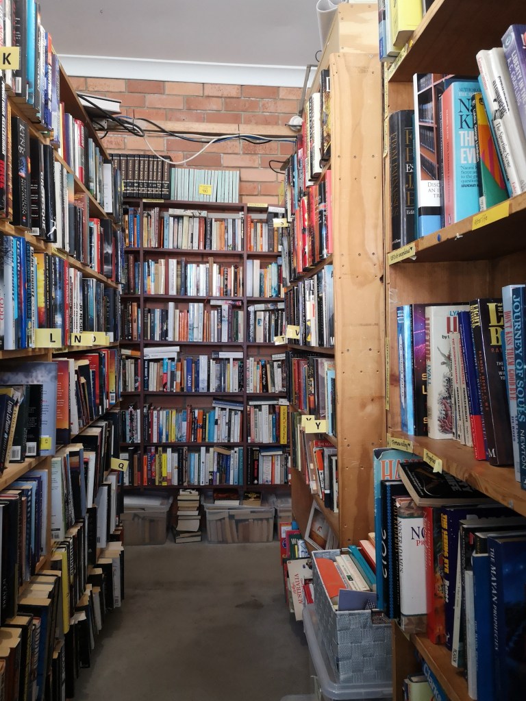 Shelves full of books line all three walls ahead of the camera