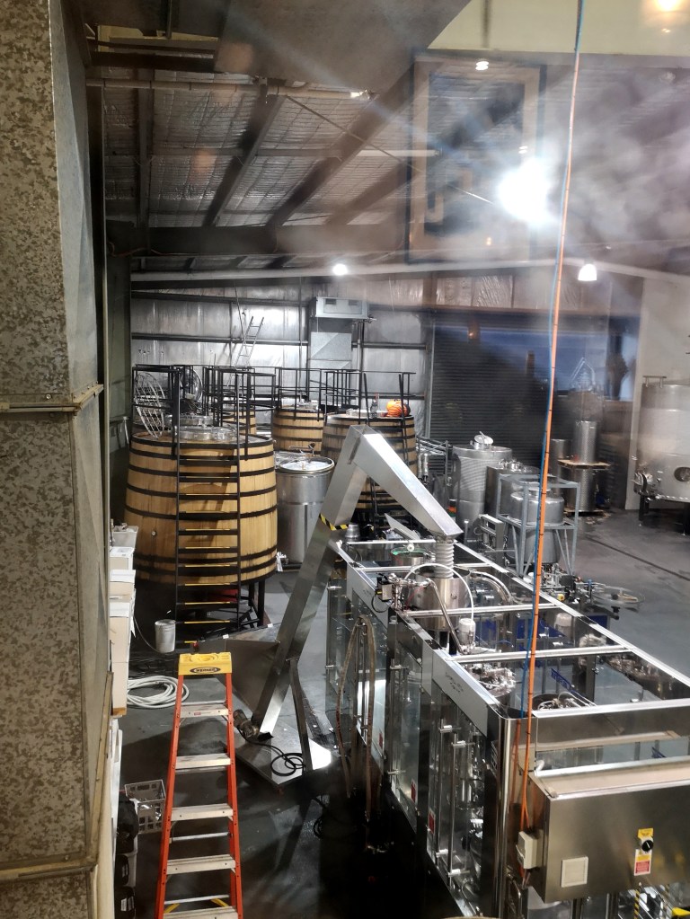 Barrels and bottle machines in the factory of a vineyard