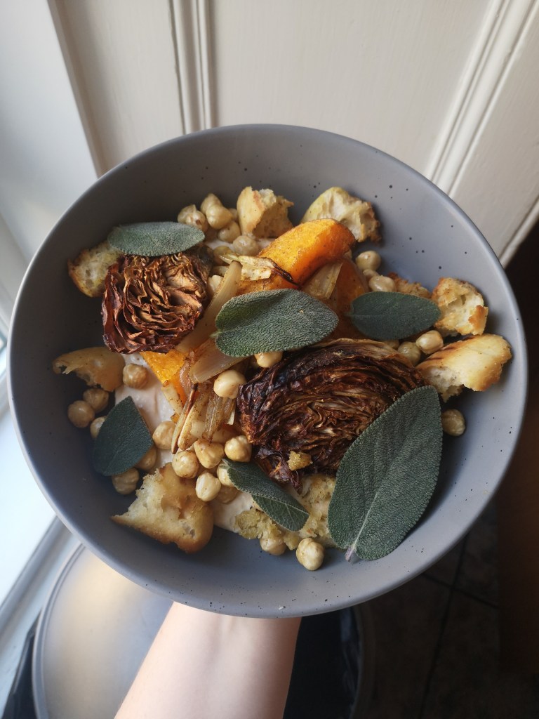 A dish with roasted vegetables, croutons and leaves of sage