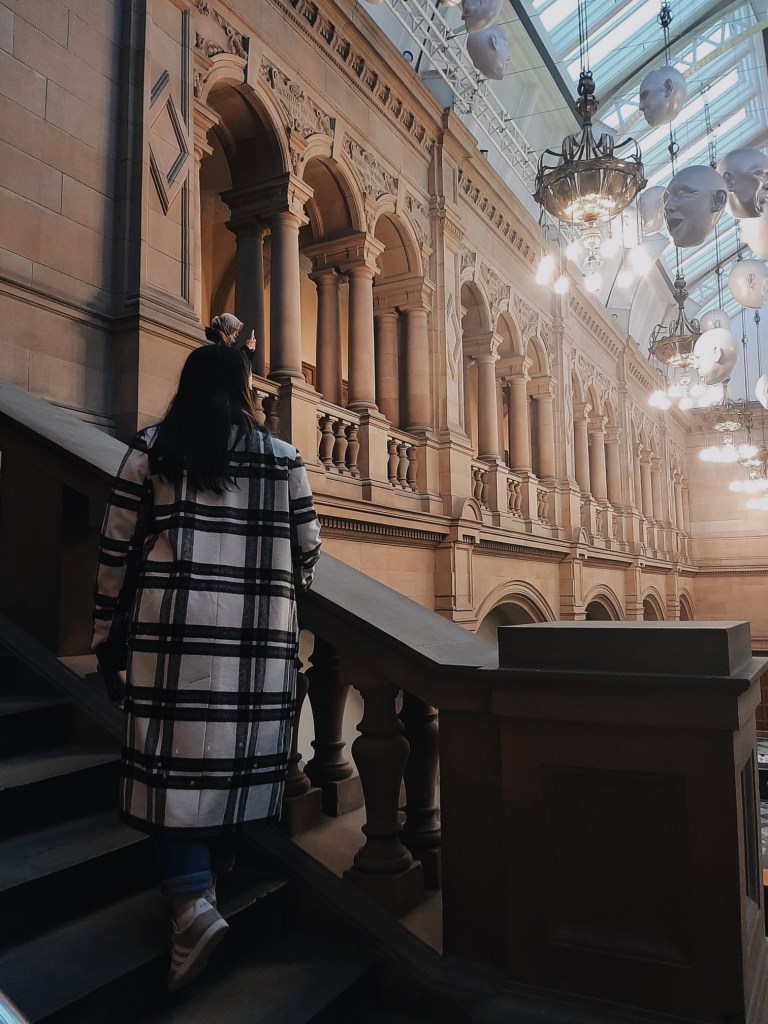 In a grand stone museum with columns, I walk up a big staircase