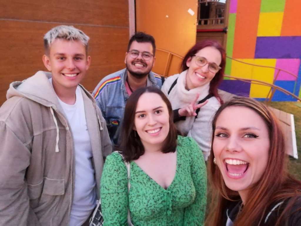 Five pals smiling together in a selfie after a show