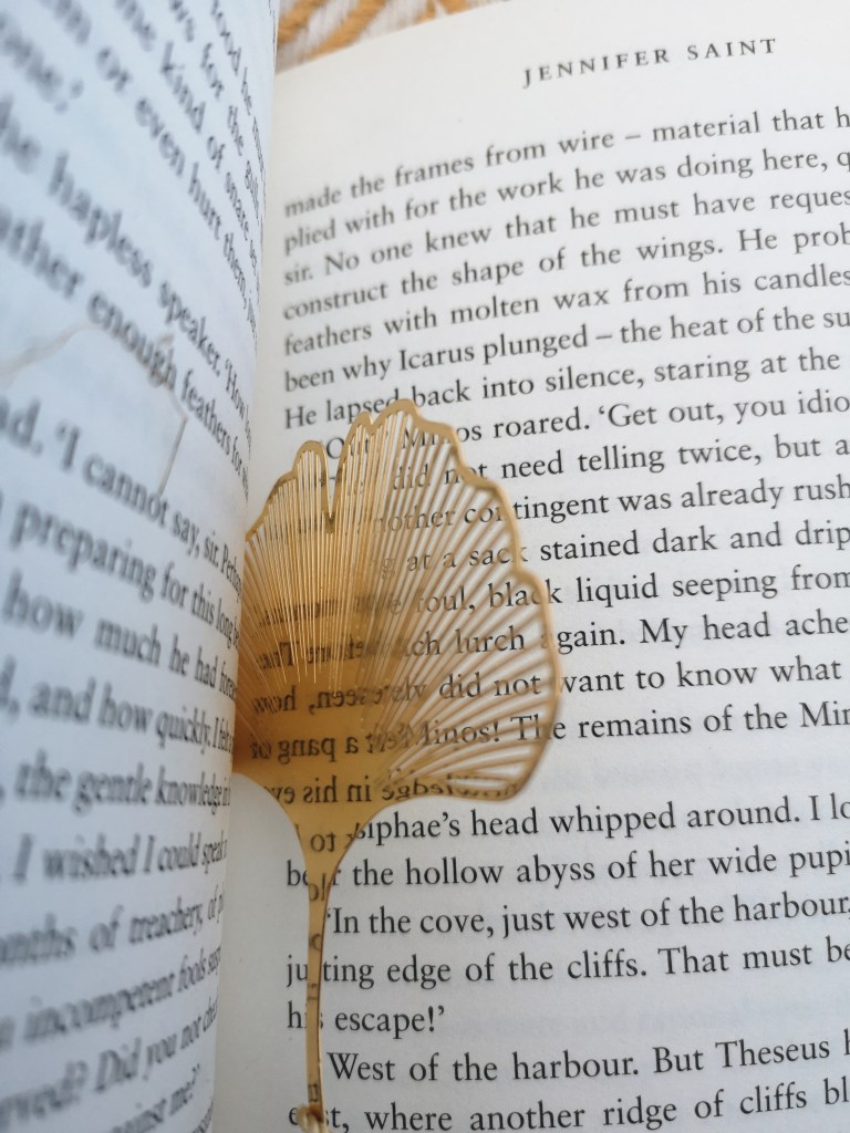 My shiny gold leaf shaped bookmark reflects the words on the pages it's stuck between