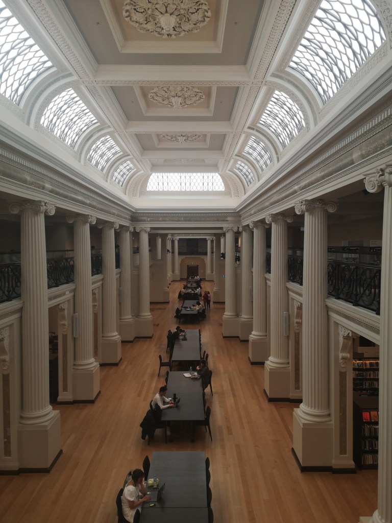 A grand reading room in the library in Melbourne, with columns lining the room
