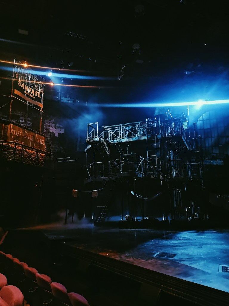 Blue lights flare behind a structure of fire escapes with platforms and stairs 