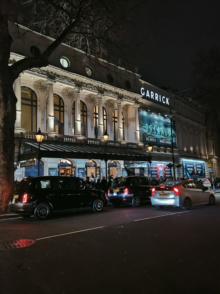 The exterior of the Garrick Theatre with cream columns and a big poster that says Orlando 