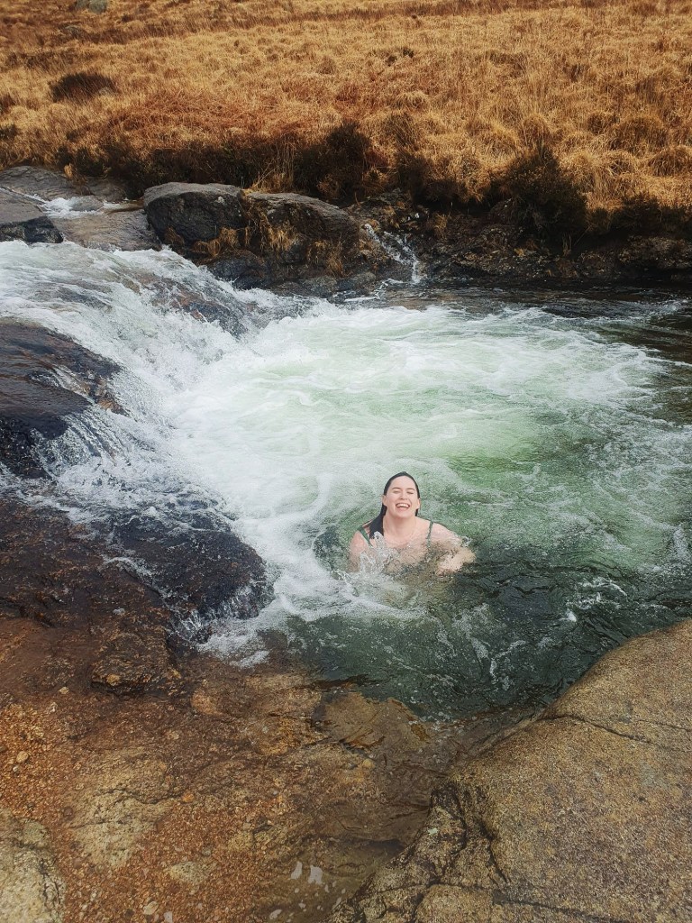 I swim in a pool of water smiling in shock at the cold