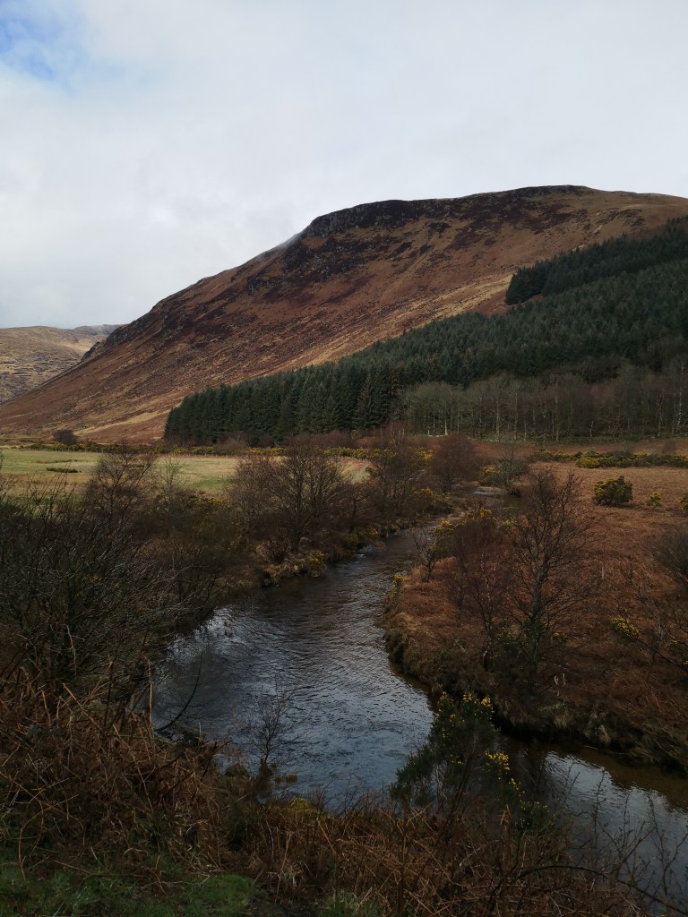 A river weaves through a beautiful valley of mountains