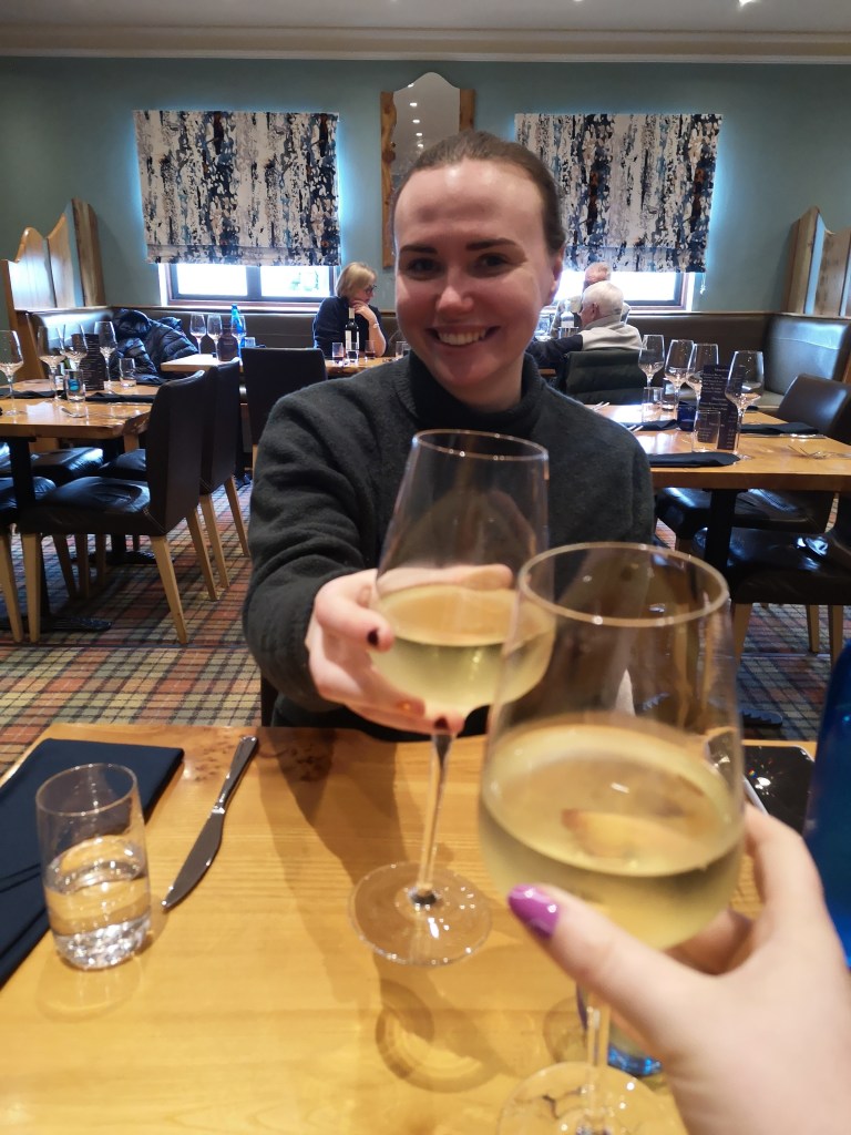 Helen holds up a glass of wine to cheers my glass