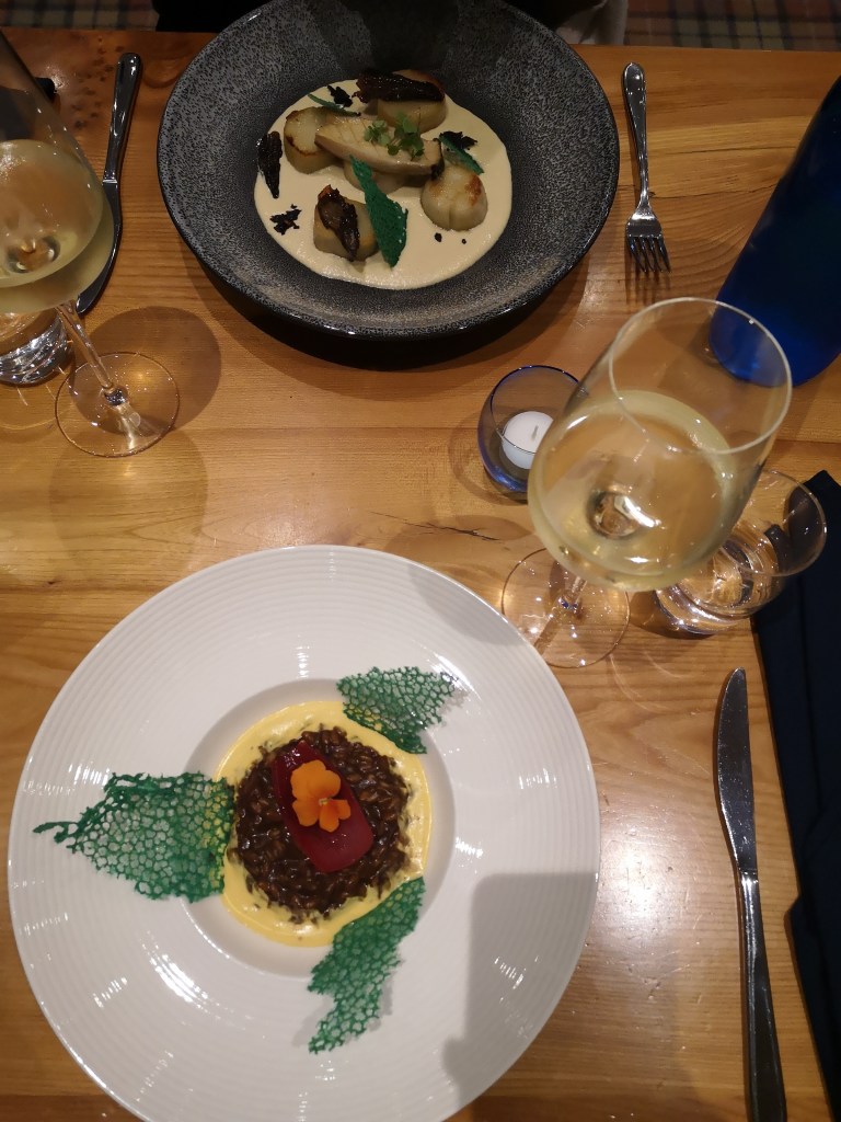 Flatlay of two dishes and two glasses of wine