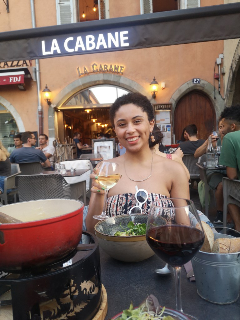 Danielle smiles at me while holding her glass of wine