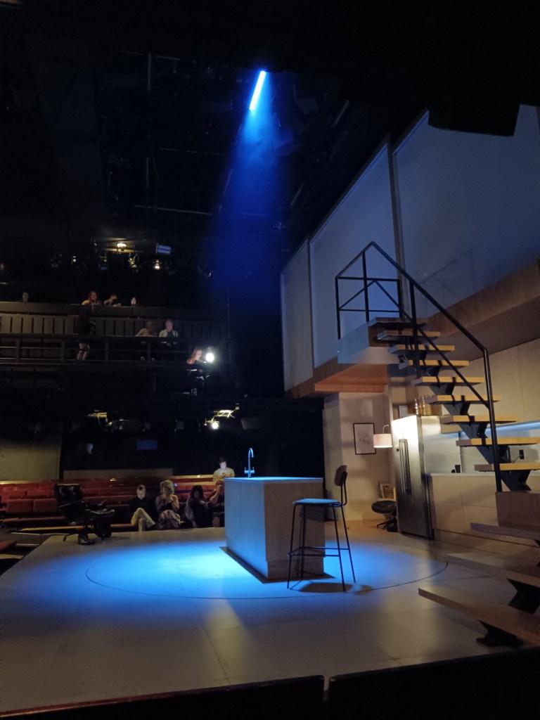 The simple stage depicting a kitchen and staircase