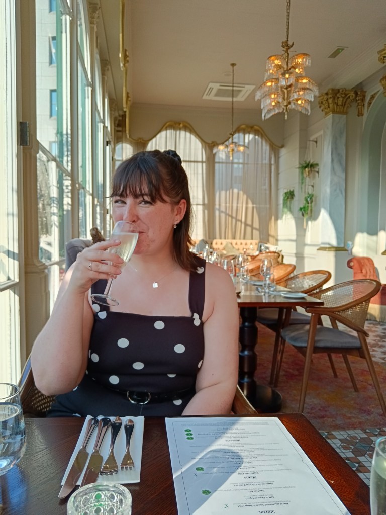 Erin sips prosecco in an airy dining room