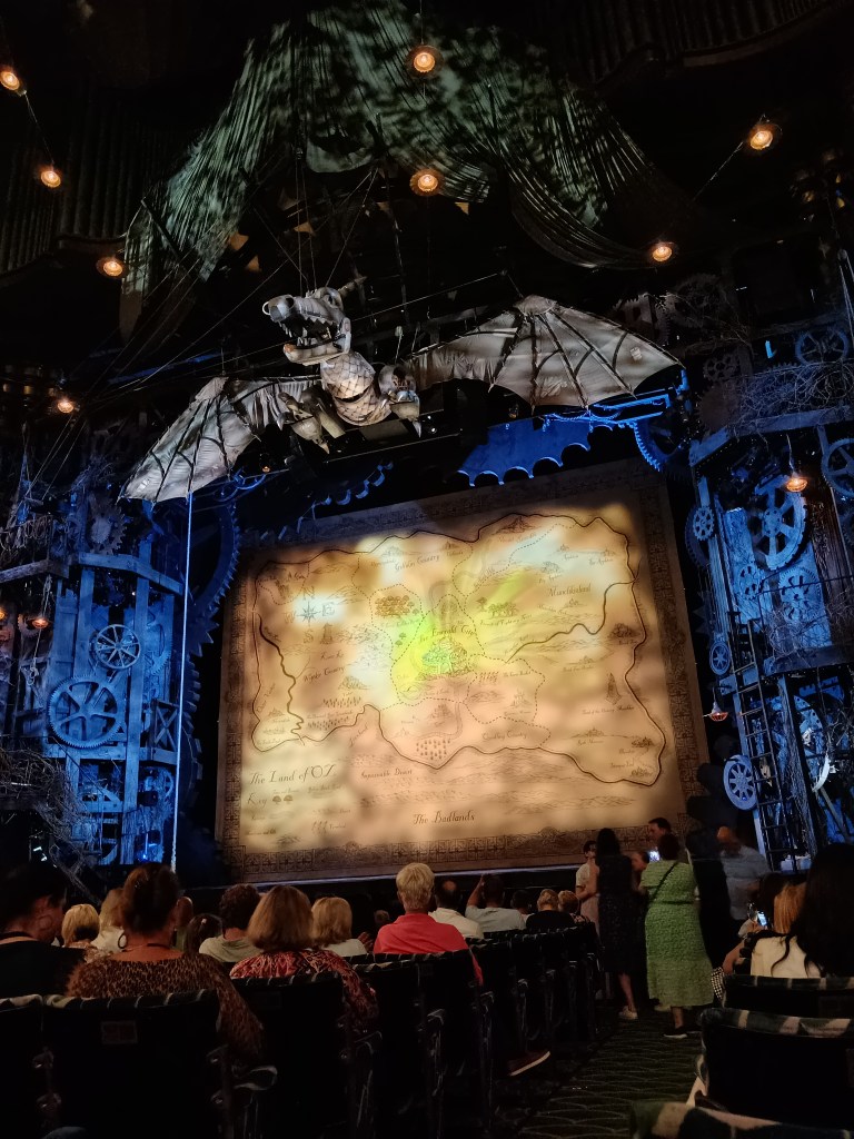 The Wicked stage with a map on the curtain and the time dragon suspended above the stage