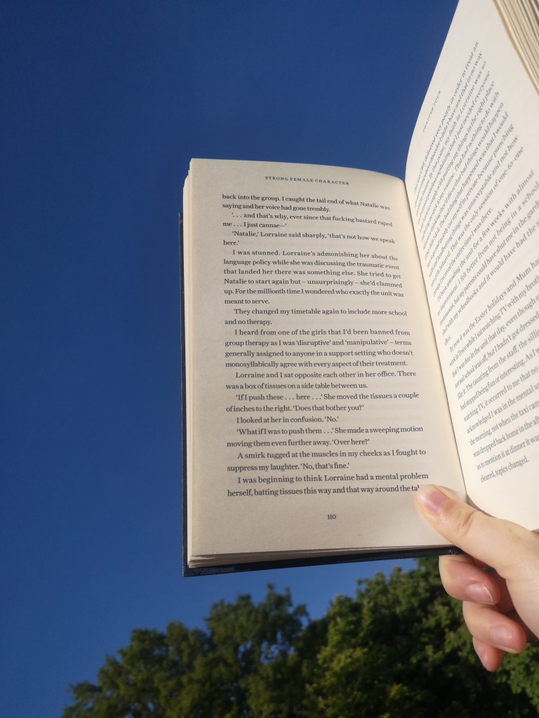 An open book held in front of a blue sky