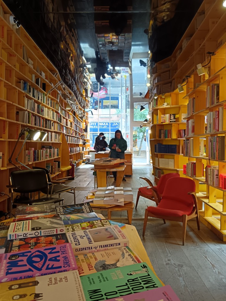 A gorgeous yellow bookshop with a mirrored roof