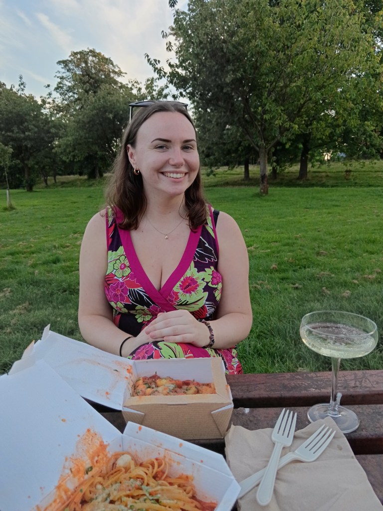 My friend and I sit in the park with takeaway pasta and prosecco
