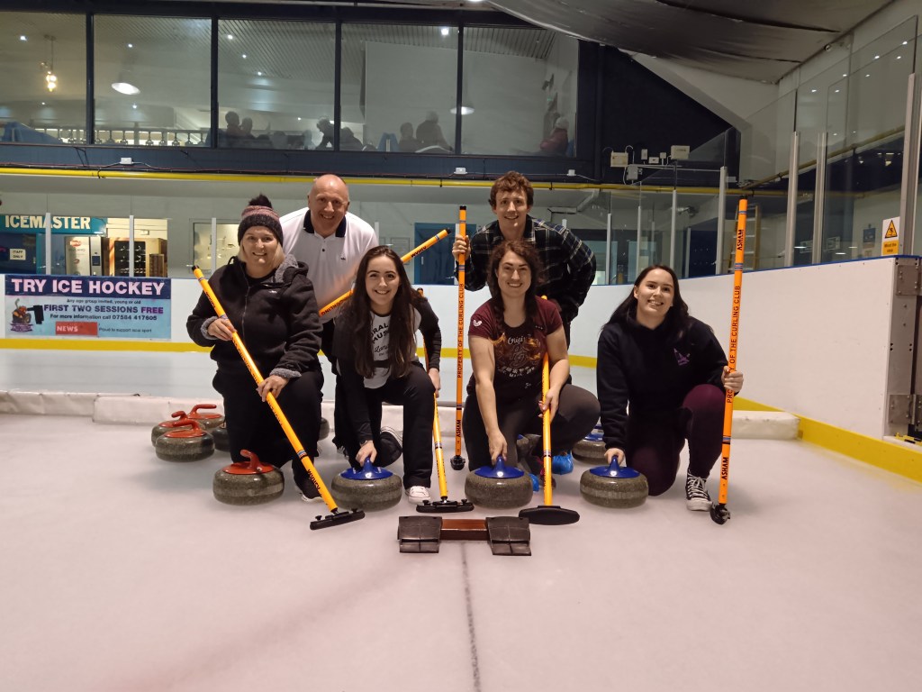 My family pose with curling stones and brushes