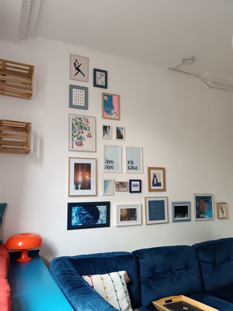 An L shaped gallery wall of photography and illustration art