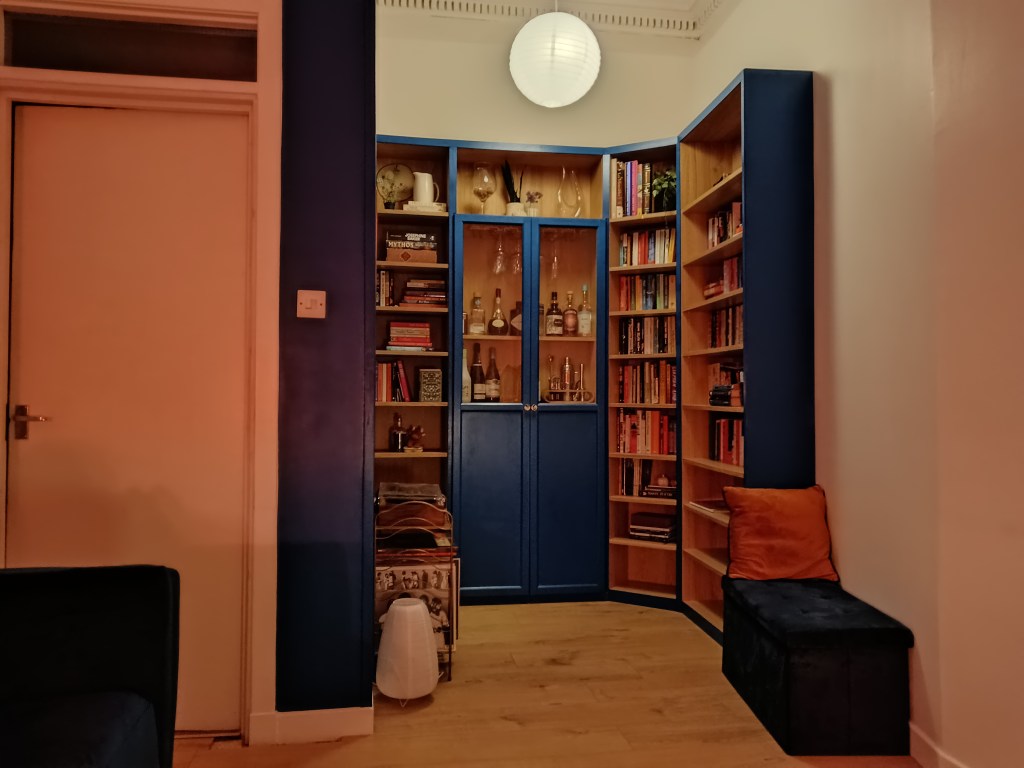 A gorgeous blue bookshelf in a cosy room
