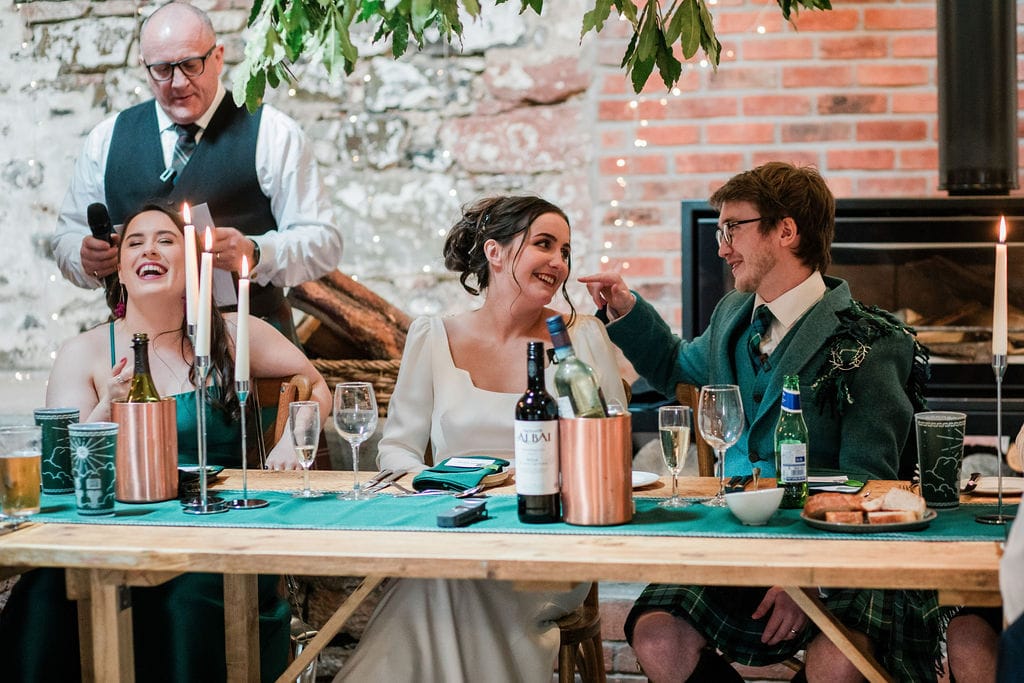 Bride and groom and me laugh at dinner table