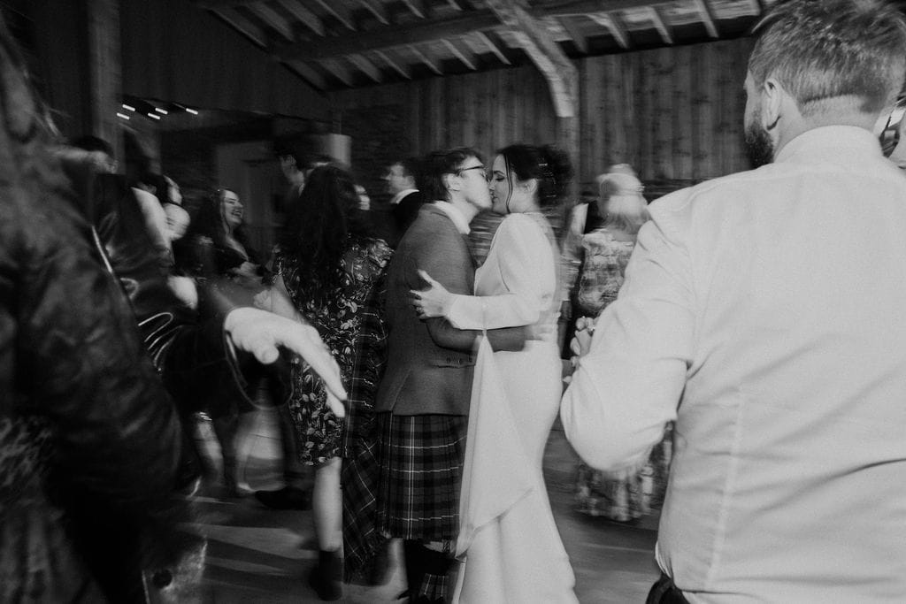 Bride and groom kiss one another on the dancefloor