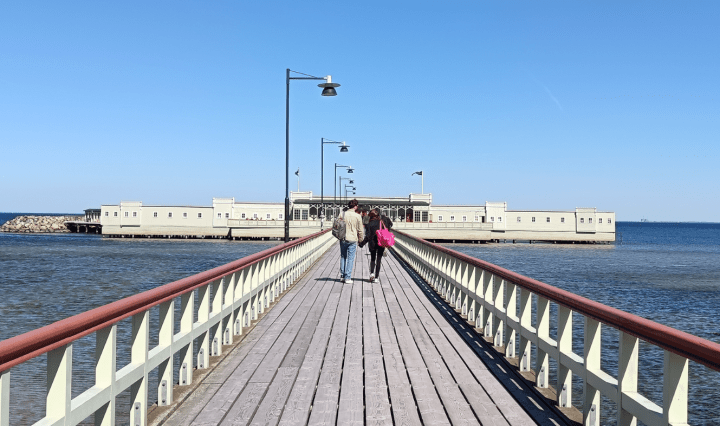 A green building at the end of a long boardwalk