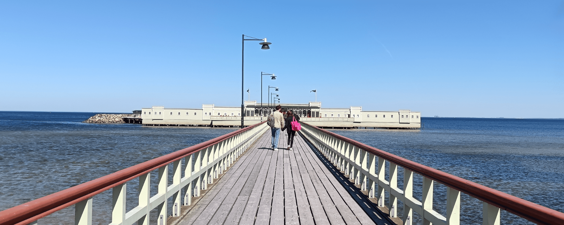 A green building at the end of a long boardwalk