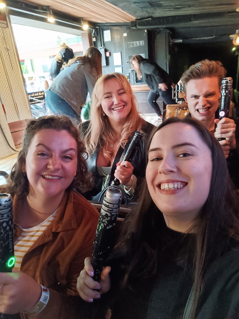 We smile while holding laser shooters on a ride