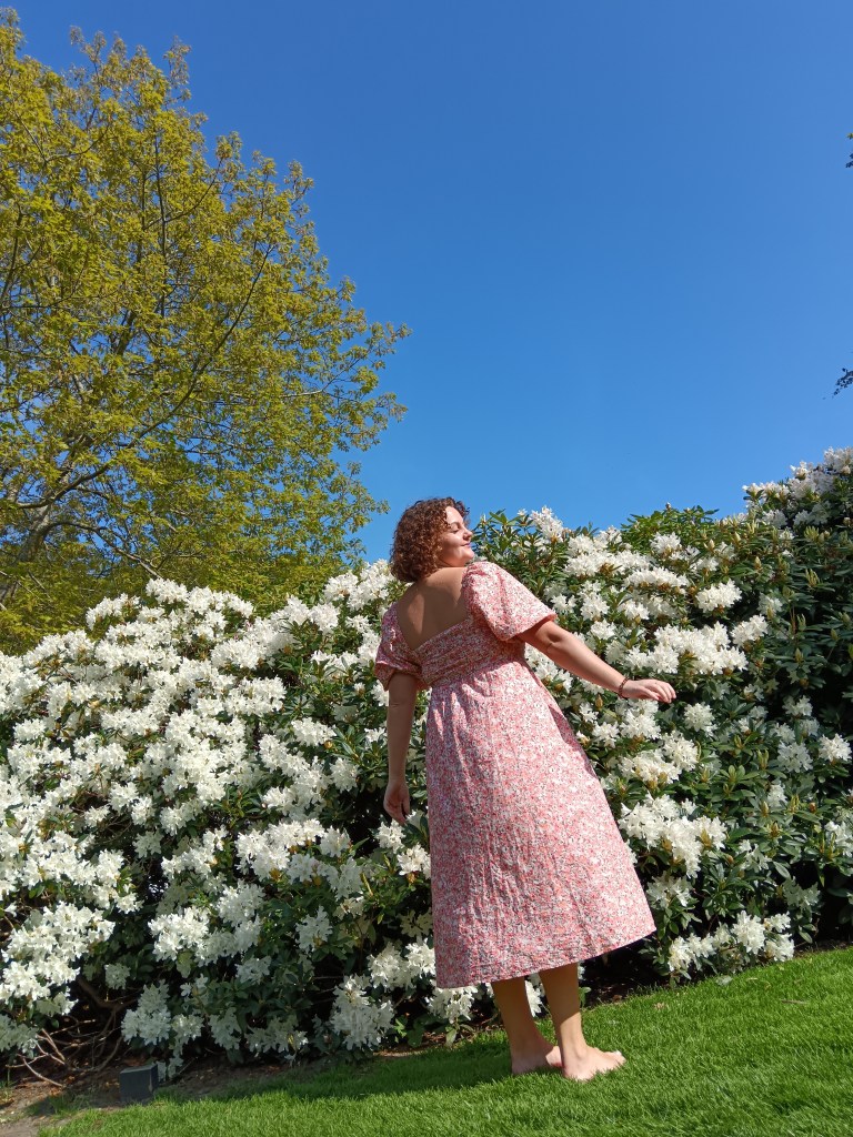 Laura spins around beside flowers